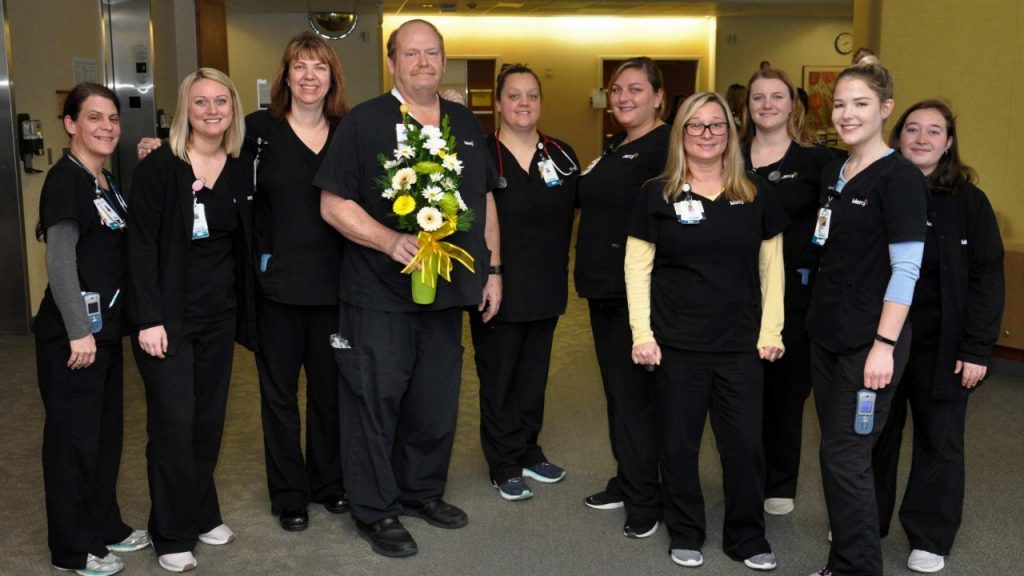 Randy Wray, RN, (holding flowers) celebrates his DAISY Award with his co-workers in the cardiovascular progressive care unit (CVPCU) at Mercy Hospital South.